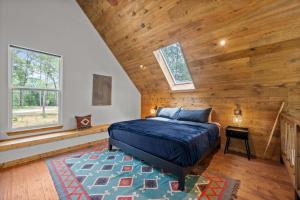 a bedroom with a bed and a wooden ceiling at LostForest Cabins in Richards