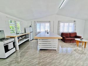 a kitchen with a stove and a couch in a room at Pearl Cottage - 2 Bedroom Entire Place in Nuku‘alofa