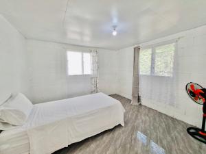 a white bedroom with a bed and a window at Pearl Cottage - 2 Bedroom Entire Place in Nuku‘alofa