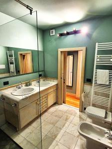 a bathroom with two sinks and a large mirror at La Pigna Suites in Verona