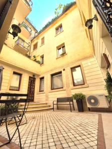 a courtyard with two benches and a building at La Pigna Suites in Verona