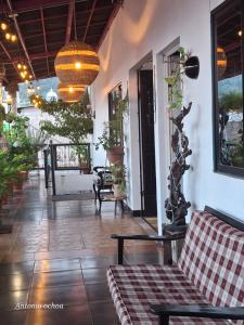 a porch of a house with a couch and a chandelier at Casaca in Concepción de Ataco