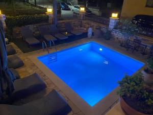 a swimming pool at night with blue lighting at Petrino Serene Studios in Kakovatos