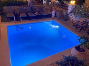 a large swimming pool with blue lights on it at Petrino Serene Studios in Kakovatos +65 photos