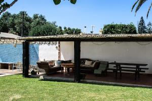 a pergola with a couch and a table in a yard at Complejo Vacacional Los Cortijillos-Solo adultos in Conil de la Frontera