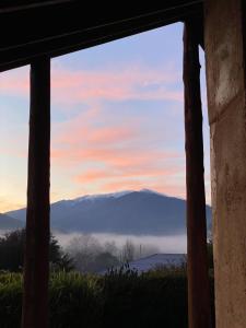 una finestra con vista sulle montagne di Earthen Escape A Cozy Couples Getaway a Tawonga
