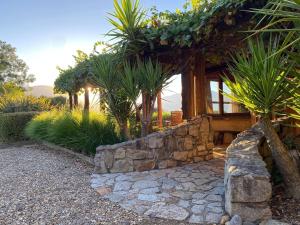 una casa con un muro di pietra e un albero di Earthen Escape A Cozy Couples Getaway a Tawonga Altre 21 foto