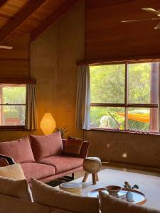 un soggiorno con divano rosso e 2 finestre di Earthen Escape A Cozy Couples Getaway a Tawonga
