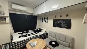 a small room with a bed and a table at Sugamo 101, close to Yamanote Line, direct access to Ikebukuro, Shinjuku, Shibuya, convenient transportation, full amenities in Tokyo