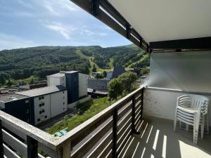 d'un balcon avec une chaise et une vue sur la ville. dans l'établissement Appartement 2 pièces vue montagne, proche pistes et lac - FR-1-814-64, à Besse-et-Saint-Anastaise