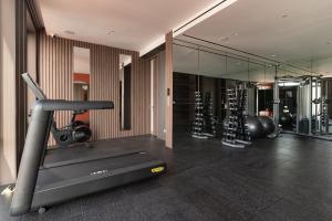 a room with a gym with a treadmill and mirrors at SOMA HOTEL Riverside in Phnom Penh