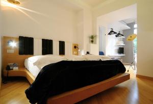 a bedroom with a bed with black and white sheets at Hotel Franklin Feel The Sound in Rome