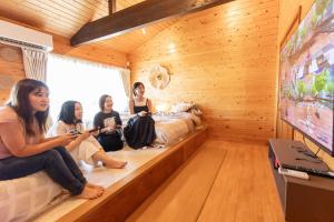 a group of women sitting in a room watching tv at Cute&Resort熱海 in Atami