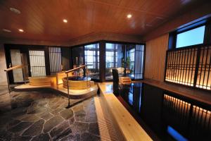 uma sala de estar com paredes e janelas de madeira em Onyado Nono Toyama Natural Hot Spring em Toyama