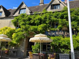 an old building with an umbrella in front of it at Cosy Cottage Overlooking Malmesbury Abbey in Malmesbury
