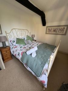 a bedroom with a bed with two stuffed animals on it at Cosy Cottage Overlooking Malmesbury Abbey in Malmesbury