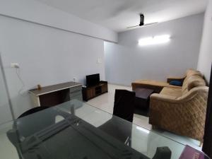 a living room with a couch and a glass table at P S rahatani in Chinchiwad