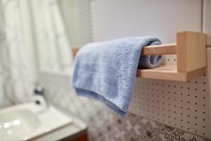 a bathroom with a blue towel hanging on a rack at Corvin Point Rooms and Apartments in Budapest