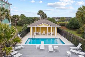 a house with a swimming pool and a deck with chairs at Seaside Townhouse W Pool & Beach Access in Fernandina Beach