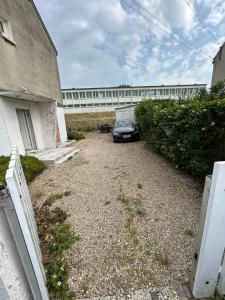 Un coche aparcado en un aparcamiento junto a un edificio. en Maison calme près Alstom, en Crespin
