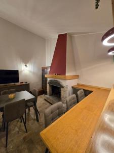 a living room with a table and a fireplace at The Pendulum in Orte +12 photos