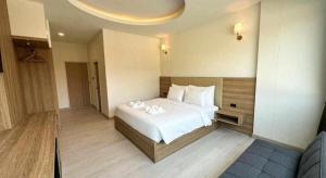 ein Schlafzimmer mit einem großen weißen Bett in einem Zimmer in der Unterkunft Baan Ingna Resort Hotel in Chaiyaphum + 52 Fotos