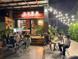 a group of people sitting at tables outside a restaurant at Wu Wu Qi伍伍七 in Zhushan