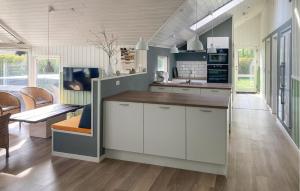 a kitchen with white cabinets and a counter top at Holiday Home Vibelunden Rødby X in Kramnitse