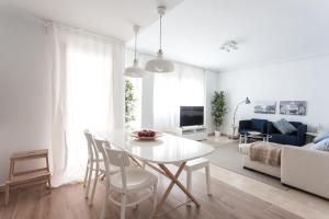 a white living room with a white table and chairs at The Lucky Flats - Pintor Sorolla in Alicante