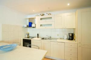 Central Apartment في دوبروفنيك: مطبخ مع دواليب بيضاء ومغسلة