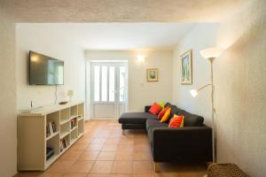 Central Apartment في دوبروفنيك: غرفة معيشة مع أريكة سوداء ووسائد برتقالية