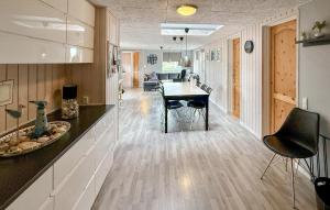 a kitchen and dining room with a table and chairs at Four-Bedroom Holiday Home In Haderslev in Diernæs