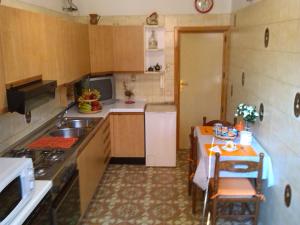 eine Küche mit einem Waschbecken und einem Tisch mit Stühlen in der Unterkunft Nice House wifi free bici free in Avola