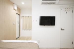 東京にあるTokyo Ueno Mia Hotelの壁に薄型テレビが取り付けられた部屋