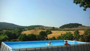 two girls are sitting in a swimming pool at Agrihouse in Bracciano