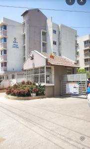 a building with a parking lot in front of it at Home Stay 1 BHK Apartment Electronic City -Oakwood in Attibele +14 photos