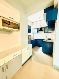 a kitchen with blue and white cabinets at Home Stay 1 BHK Apartment Electronic City -Oakwood in Attibele