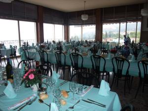 ein Esszimmer mit Tischen und Stühlen mit blauen Tischdecken in der Unterkunft Hotel Miralago in San Zeno di Montagna