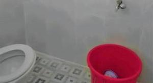 a red trash can in a bathroom with a toilet at OYO Life 91323 Omah Victoria Homestay & Culinary in Wonogiri +93 photos