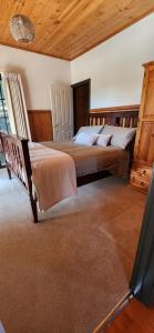una camera da letto con due letti e soffitto in legno di Shiprock Farm Cottage 