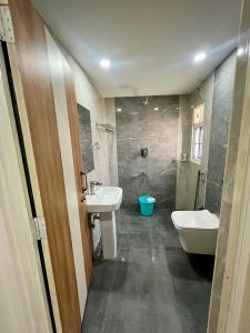 Un baño con lavabo, bañera e inodoro. en ClubGreens, en Jorhat