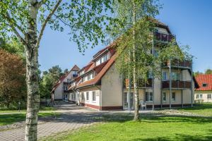 un edificio con árboles delante de él en BSW-Ferienwohnungen Zingst, en Zingst