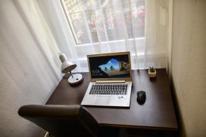 a laptop computer sitting on a desk next to a window at Corvin Point Rooms and Apartments in Budapest