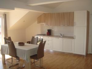 a kitchen with a table and chairs and a kitchen with a table and a counter at Apartments Jelicic in Selce