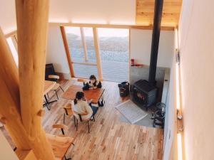 two women sitting in a room with a fireplace at Cider Barn &more in Iida