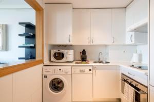 cocina con lavadora y microondas en Apartamentos Madrid Anderson, en Madrid