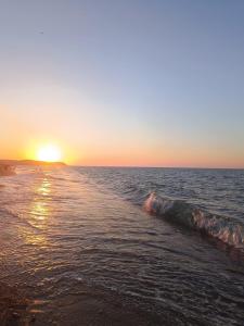 einen Sonnenuntergang am Strand mit dem Meer in der Unterkunft Airport Confort Guest House in Arnavutköy