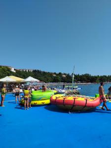 a group of people on a beach with boats at Apartment Crikvenica Trg Duga in Crikvenica