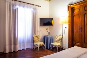 Televízia a/alebo spoločenská miestnosť v ubytovaní Palazzo Montalbano