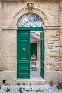 una entrada a un edificio con una puerta verde en Palazzo Montalbano, en Scicli